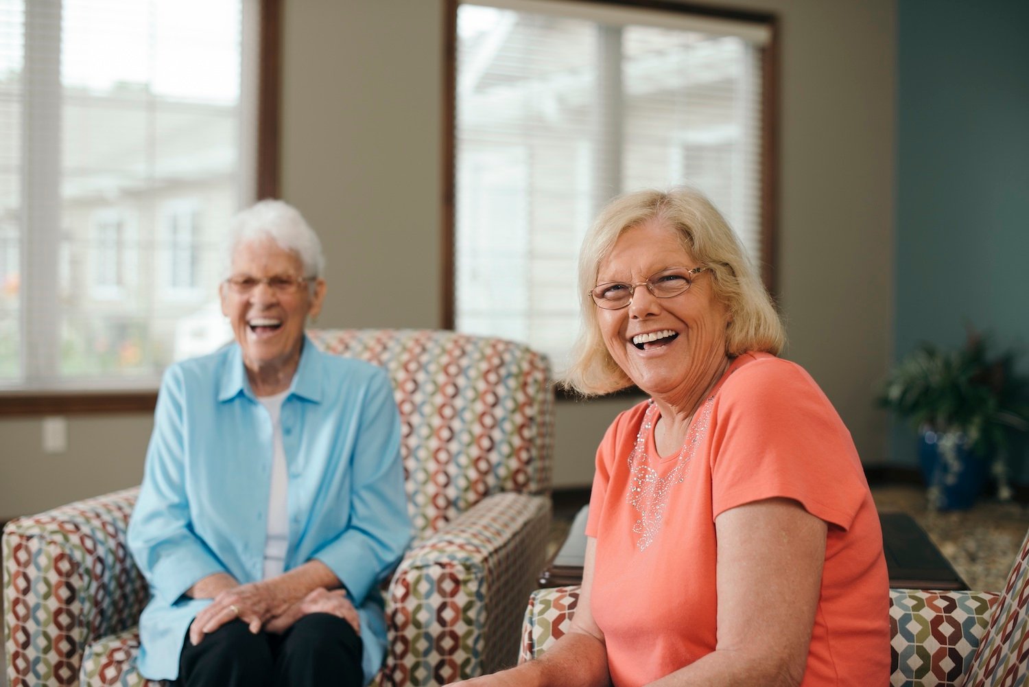 A resident and a caregiver smiling in a living room