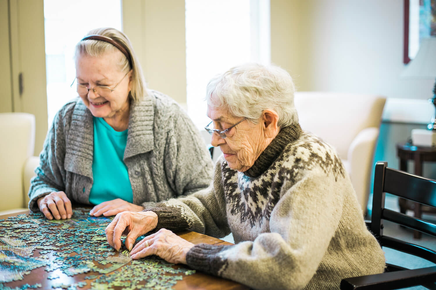 Senior women building a puzzle together