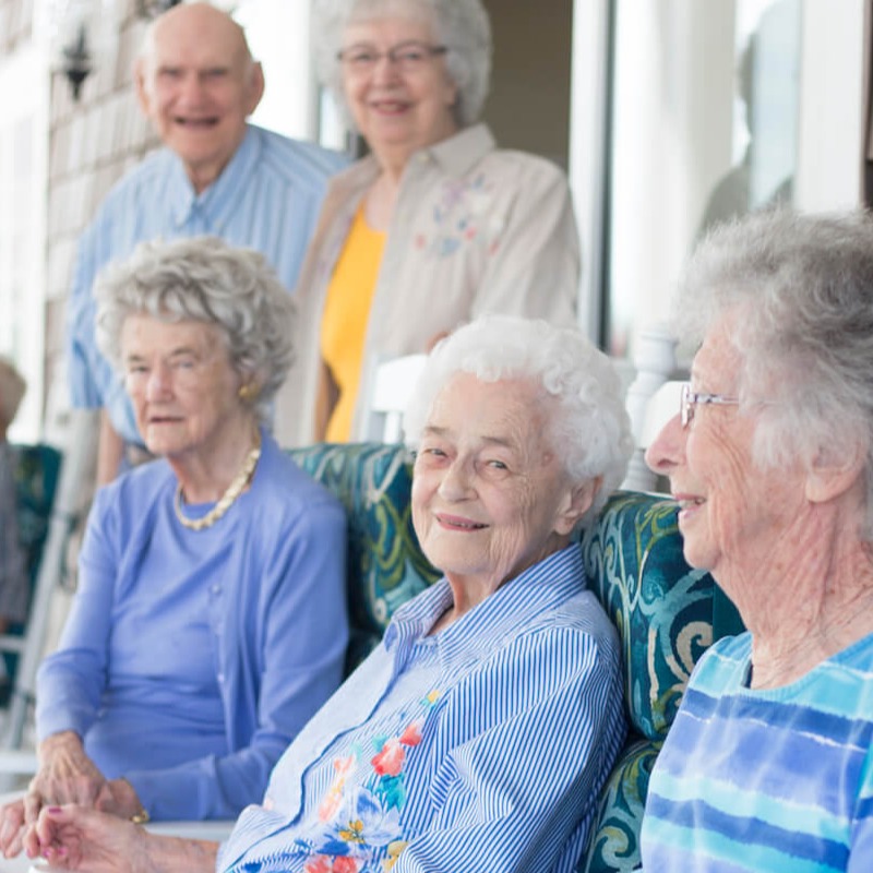 A group of residents smiling together on a patio outside