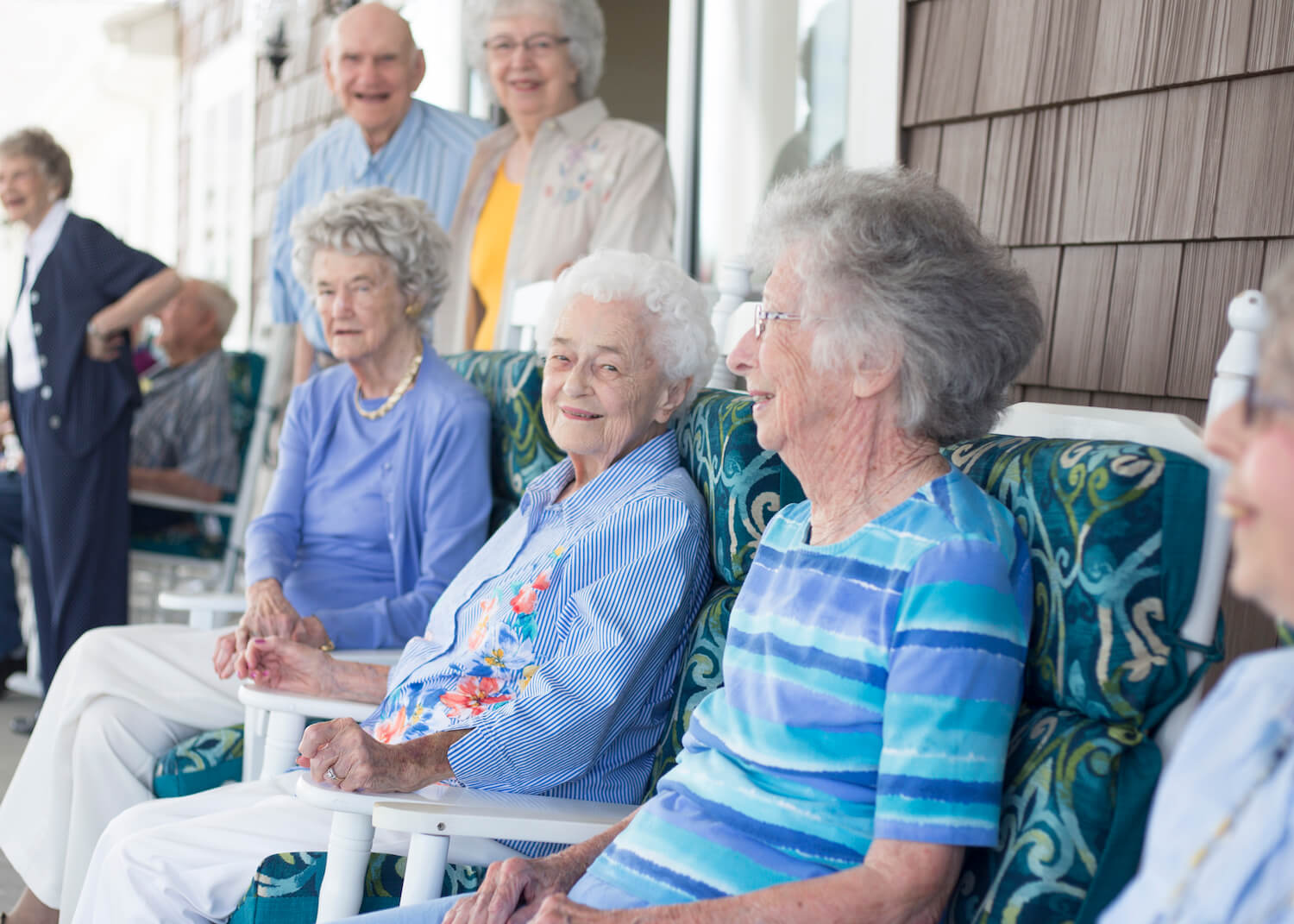 A group of residents smiling together on a patio outside