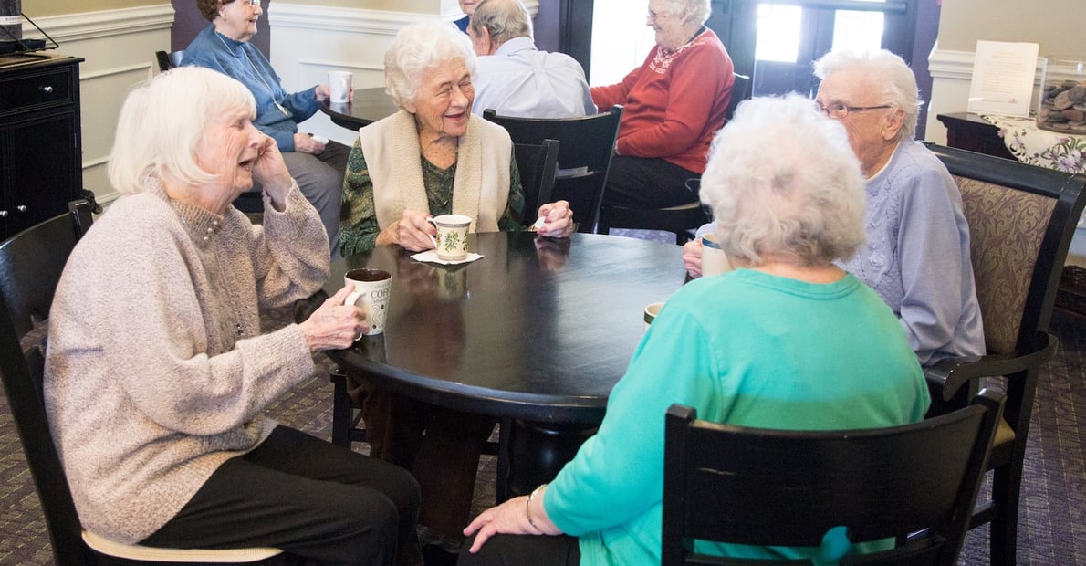Group of seniors enjoying a cup of coffee together in the community restaurant
