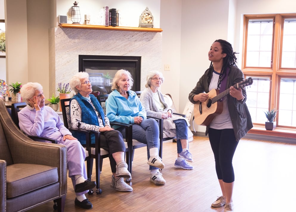 A group of senior residents listening to a live music performance