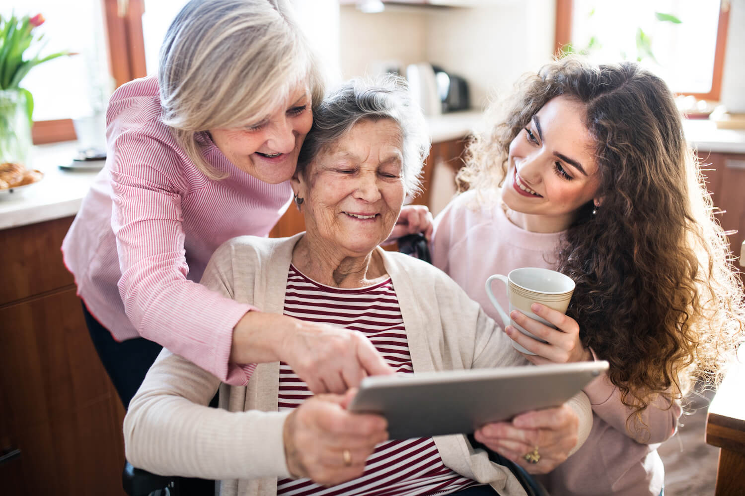 Senior woman looking at a tablet with daughter and granddaughter