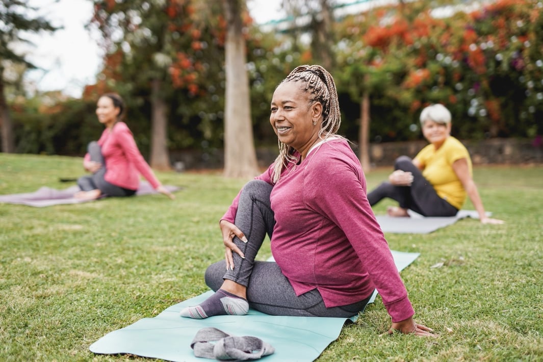 Multiracial women doing yoga exercise with social distance for coronavirus outbreak at park outdoor - Healthy lifestyle and sport concept-1308292203