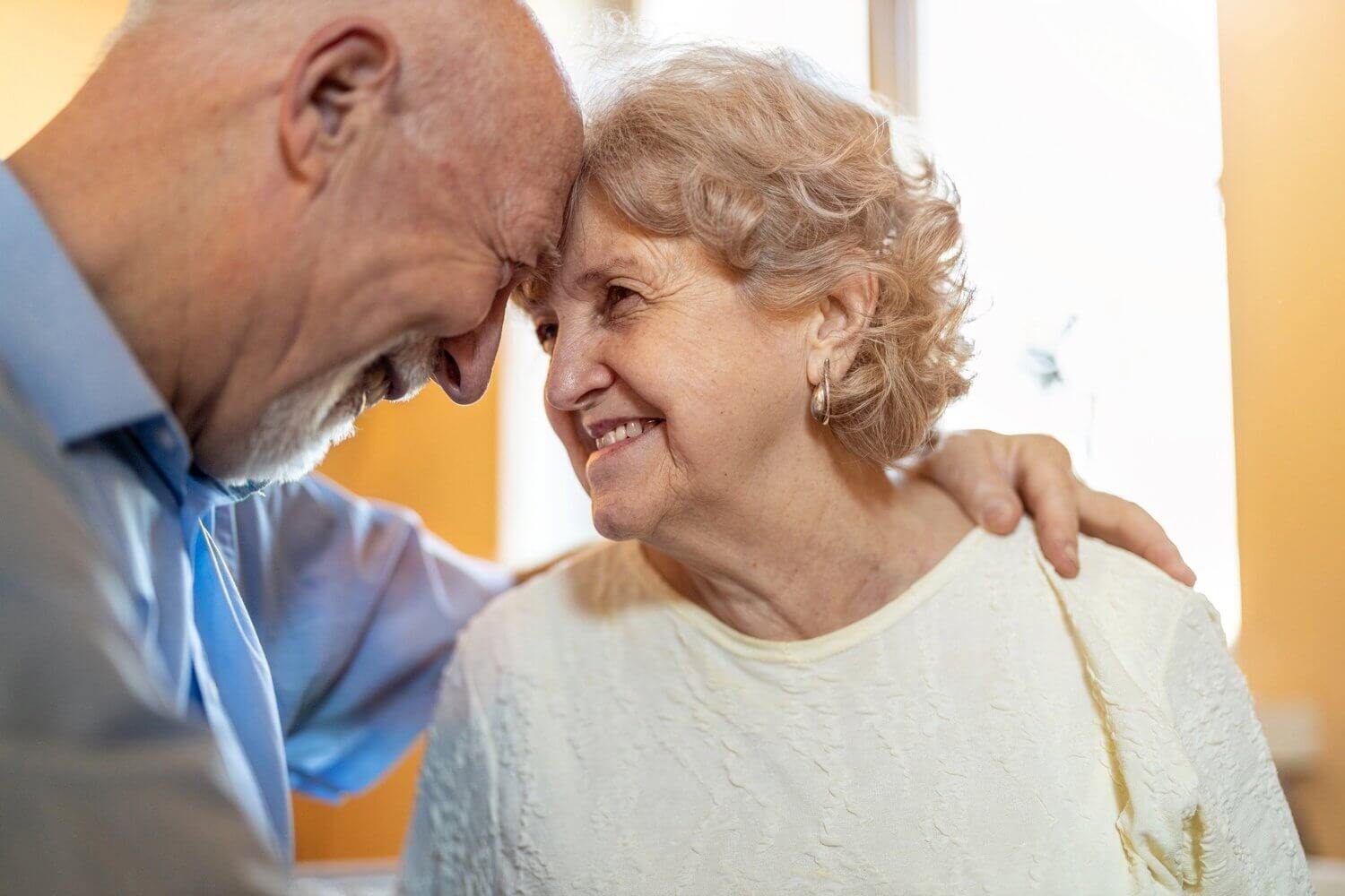 Happy senior couple embracing and pressing their foreheads together