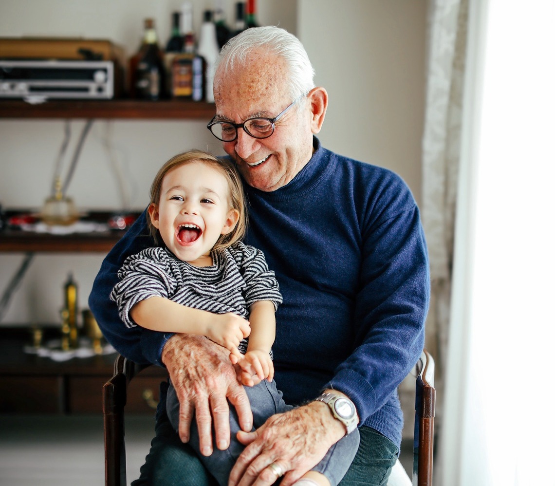A senior man holding his grandson