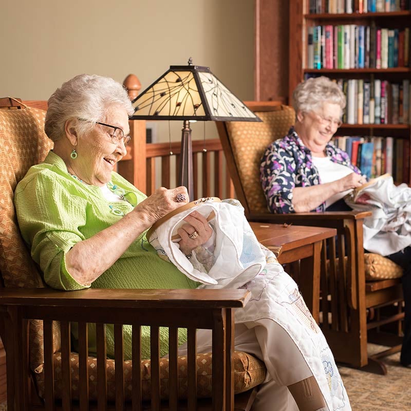 Two senior women knitting together
