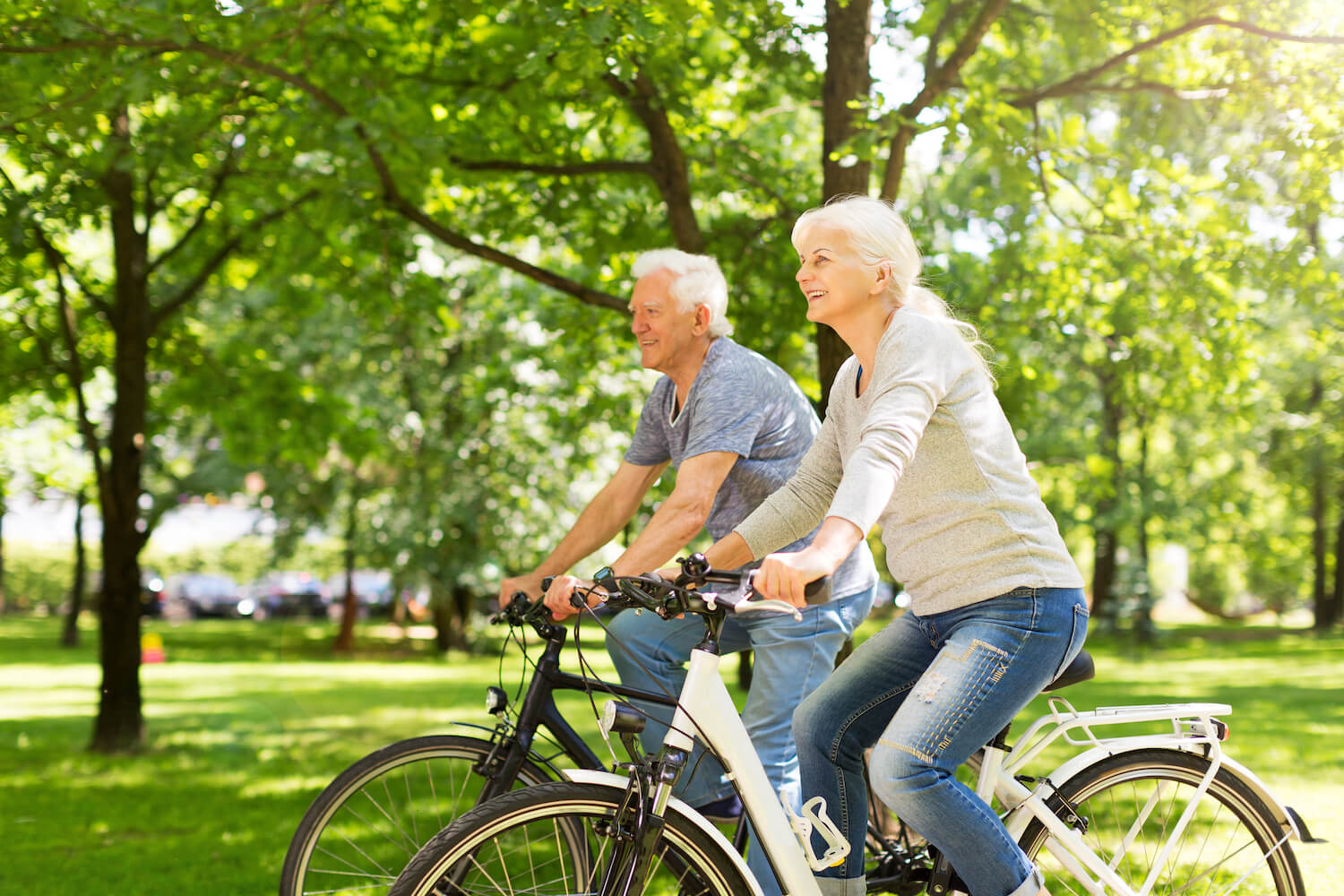 Senior couple riding bikes in park