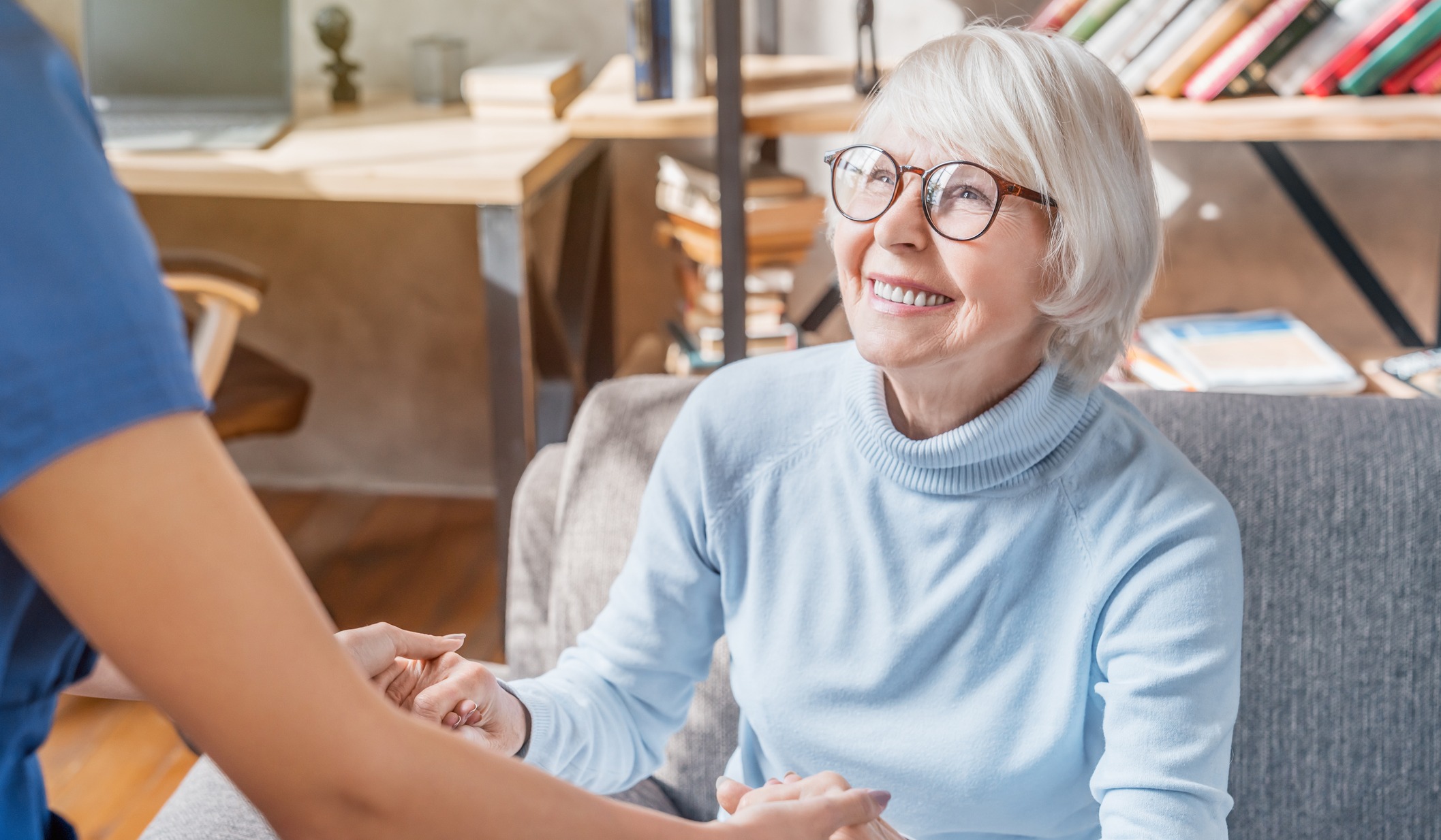 Senior woman holding hands with caregiver