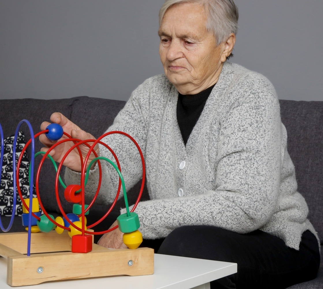 A senior woman playing with a sensory toy A senior woman playing with a sensory toy