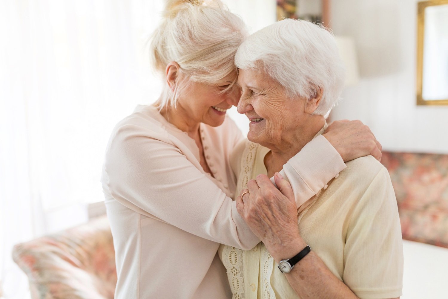 Two senior women smiling and embracing