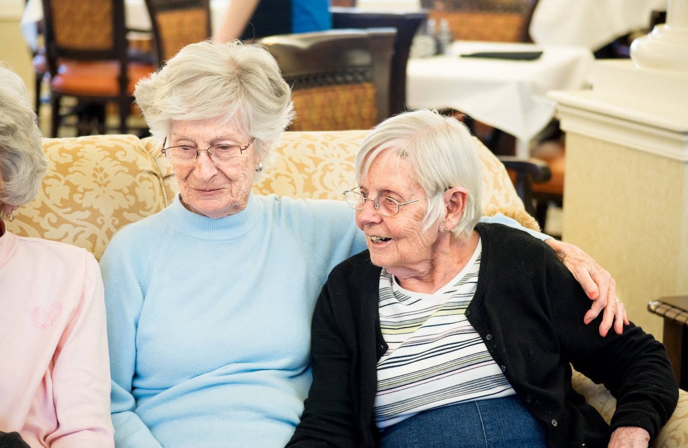 Senior women embracing on a couch Senior women embracing on a couch