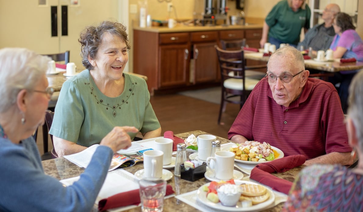 A group of seniors eating together in the community restaurant