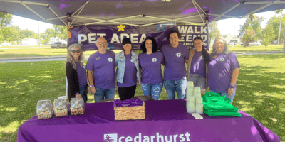 A Cedarhurst fundraising team smiling together at their tent at a Walk to End Alzheimer's event.
