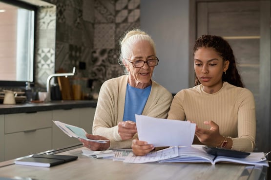 Adult daughter looking at papers and researching how to get power of attorney for elderly parent