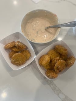 Two small paper trays with fried green tomatoes.