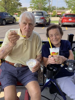 A senior couple enjoying ice cream together on a sunny day.