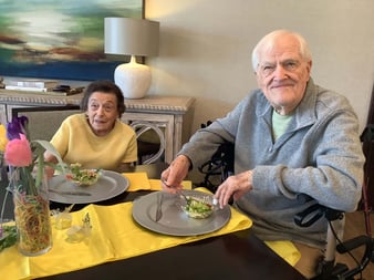 A senior couple smiling and enjoying dinner together.