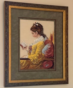 A painting of a woman in a Victorian era dress reading a book.