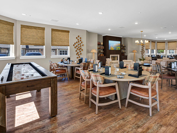 The Cedarhurst of Frankfort Independent Living at Cedarhurst Cottages clubhouse, complete with shuffleboard, a TV lounge, and board games and activities.
