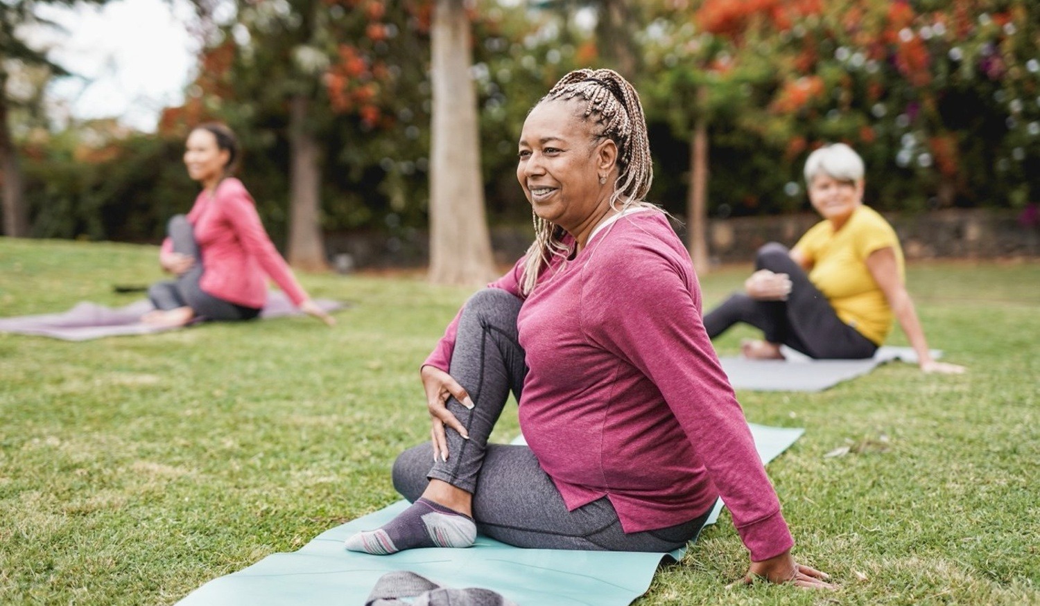 seniors stretching on exercise mats outside