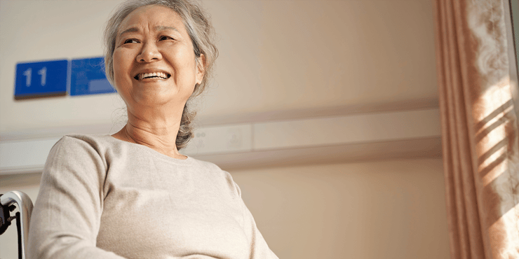 Smiling senior woman sitting in wheelchair in senior living community