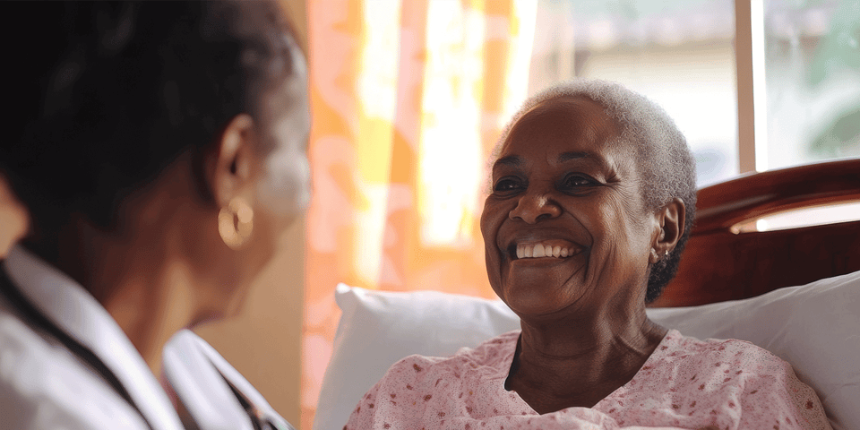  Happy senior woman in respite care smiles while being cared for by a senior living staff member