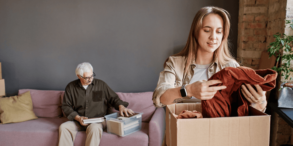Adult woman packing boxes to prepare senior for moving to a senior living community