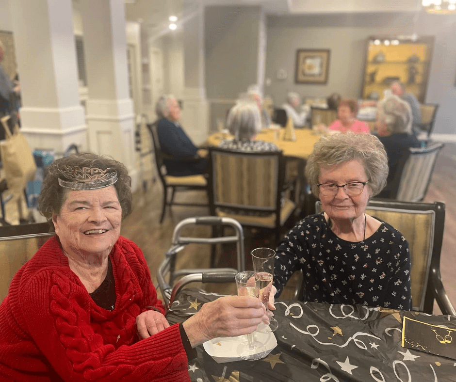 Holidays at Cedarhurst - Two senior living residents clink champagne glasses together at their community's New Years celebration.