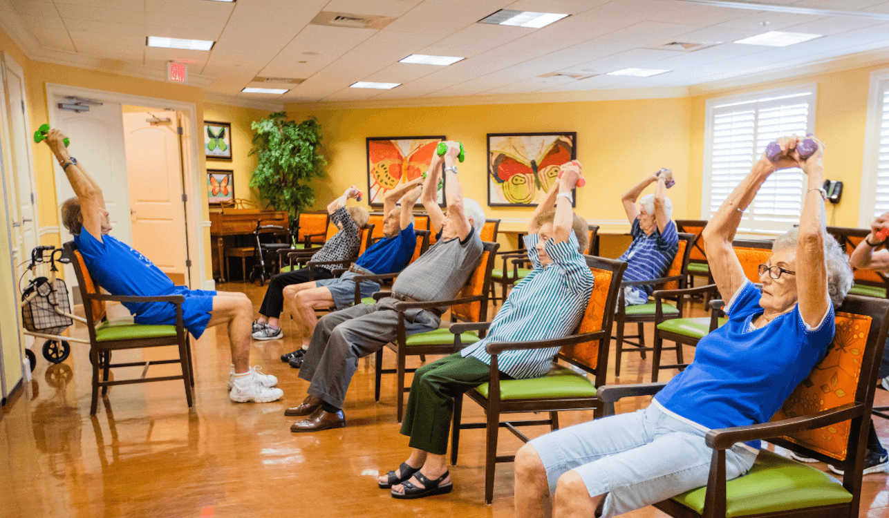 Senior living residents lifting weights together in an exercise class-1