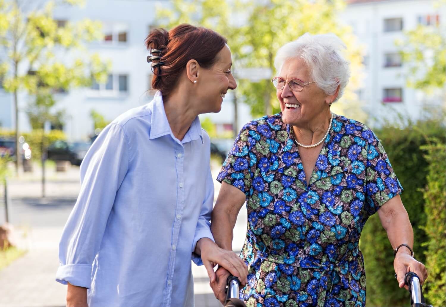 Carer helping senior with walker outdoors