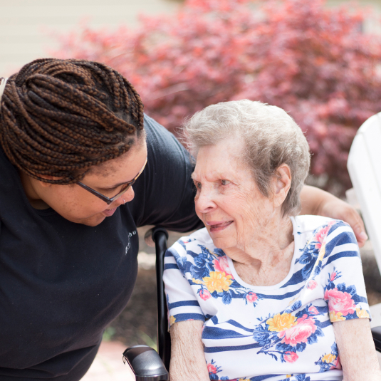 Caregiver talking to woman in a wheelchair