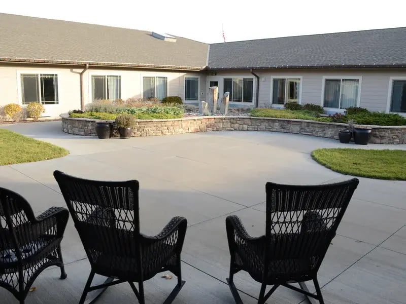Outdoor green space at Cedar Creek of High Plains with paved walking paths and raised garden beds.