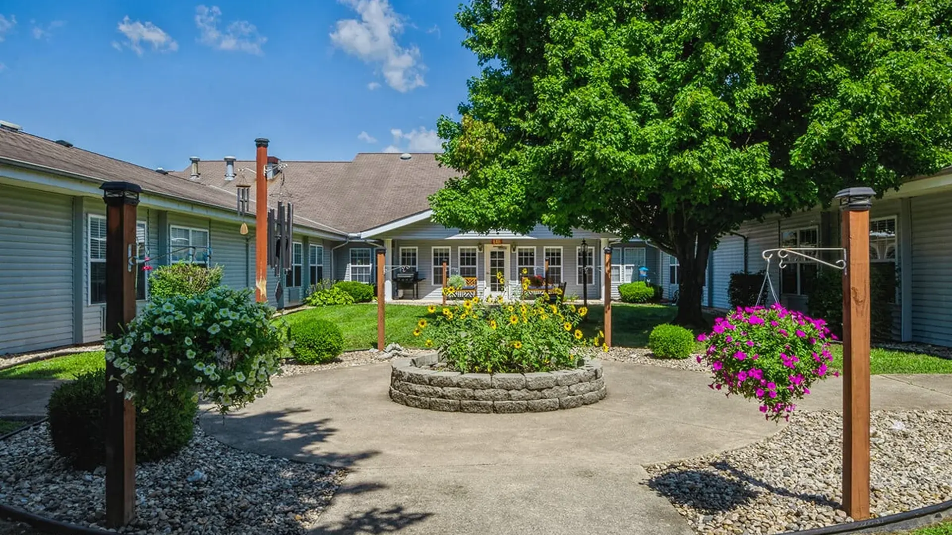 An inviting outdoor area at Cedar Creek of Logansport, showing lush green spaces and paved paths,