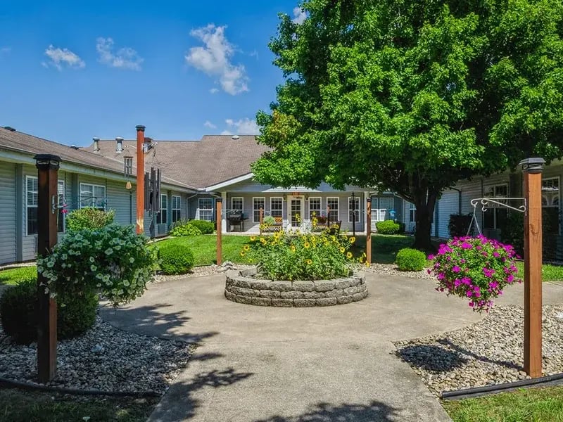 An accessible covered porch at Cedar Creek of Logansport equipped with rocking chairs and fans