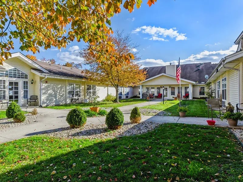 An inviting outdoor area at Cedar Creek of Muncie, showing lush green spaces and paved paths,