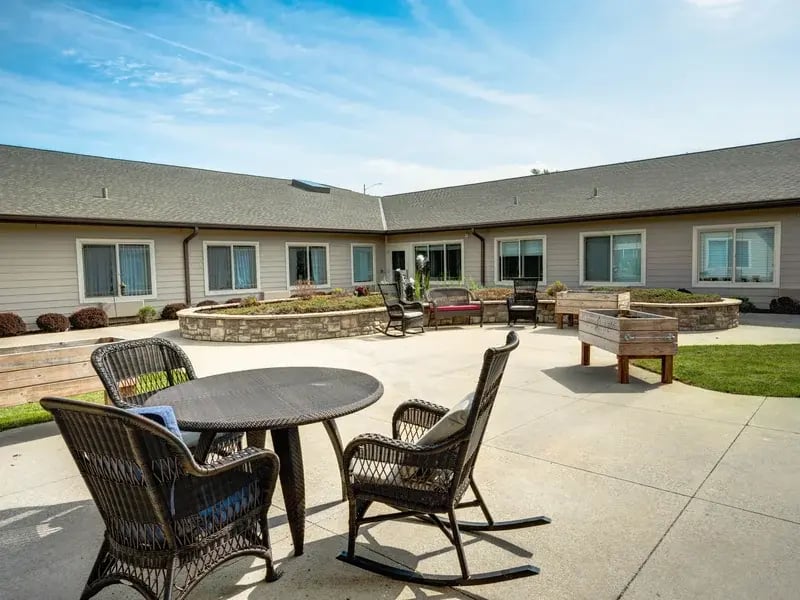Outdoor green space at Cedar Creek of Prairie Meadows with paved walking paths and raised garden beds.