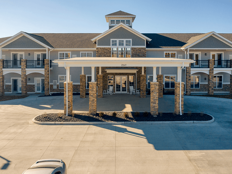 An inviting view of the Cedarhurst of Arnold senior living community from the outside, complete with the main building and its distinctive sign