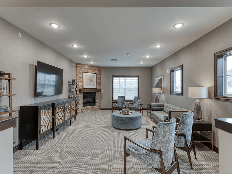 A welcoming common area at Cedarhurst of Arnold, featuring ample seating and a television, perfect for relaxation or watching programs