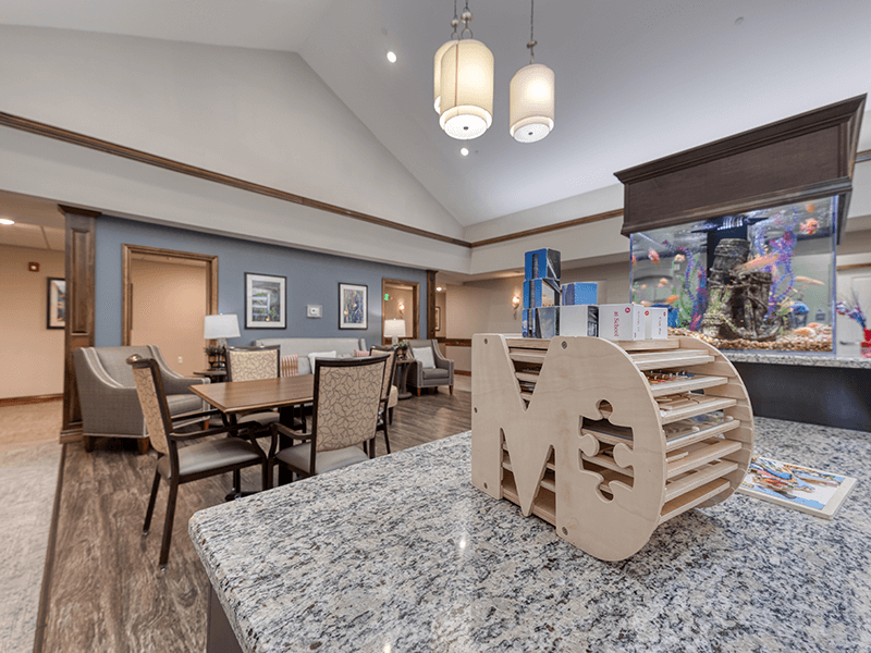 An inviting common area at Cedarhurst of Bethalto, featuring game tables and a tranquil fish tank for residents to enjoy