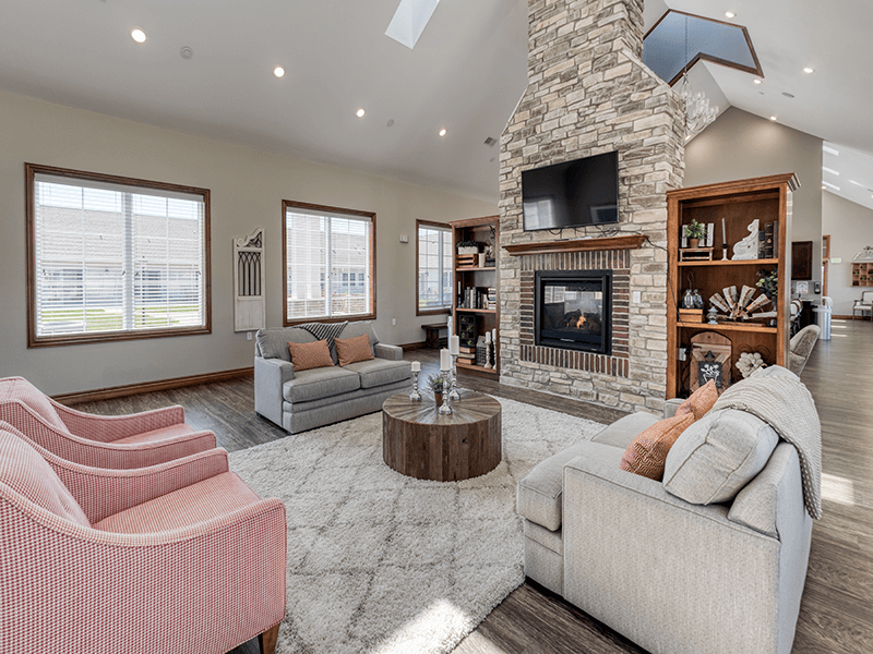 A comfortable common area at Cedarhurst of Bethalto, featuring plush seating and a cozy fireplace for residents to relax.