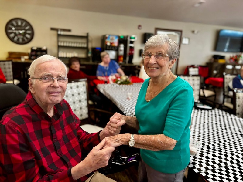 Two friends sharing a laugh during a music and movement activity at Cedarhurst of Bethalto assisted living community