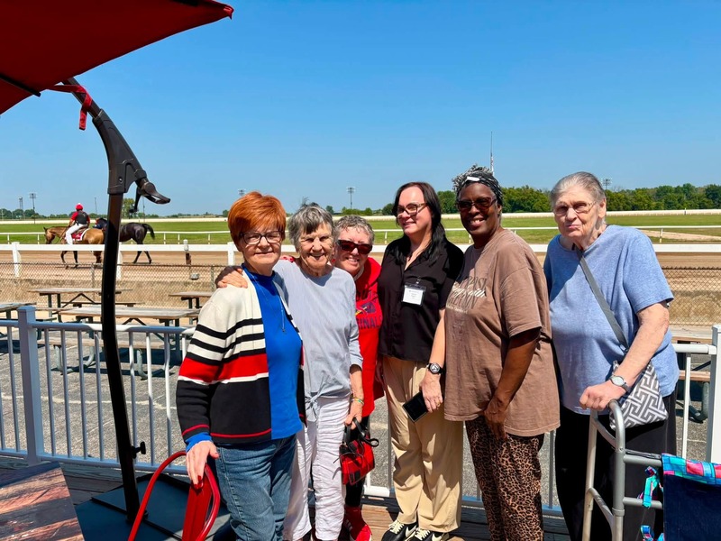 Residents and a team member from Cedarhurst of Bethalto assisted living community posing trackside at the horse races
