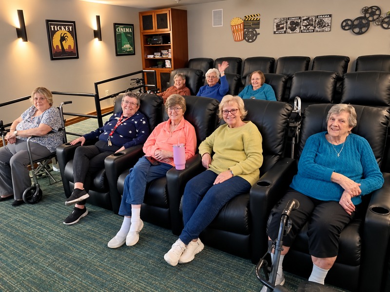Residents relaxing in leather recliners in the movie theater at Cedarhurst of Bethalto senior living community