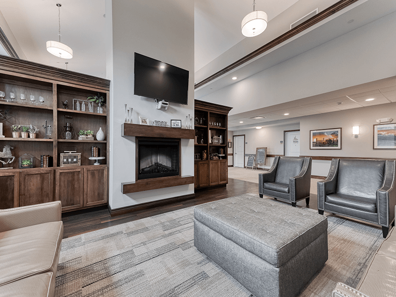Common area at Cedarhurst of Blue Springs, complete with plush seating and a welcoming fireplace, where residents can enjoy warmth and comfort