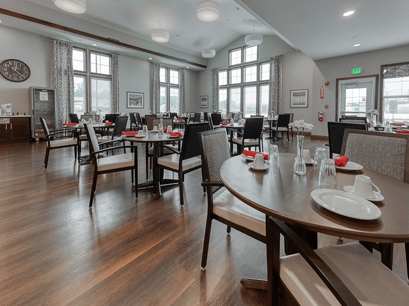 A spacious and bright dining room at Cedarhurst of Blue Springs, offering comfortable seating for meals.
