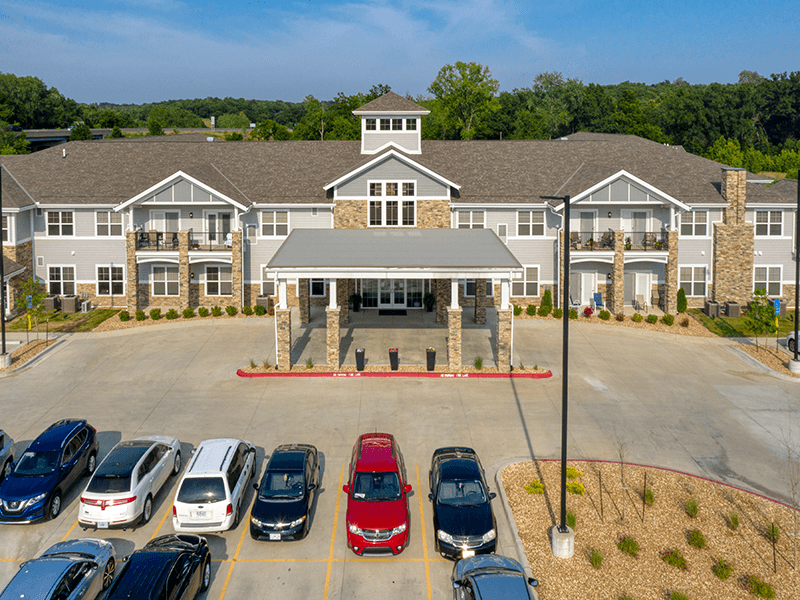 Exterior of Cedarhurst of Blue Springs senior living community, featuring a welcoming entrance and accessible parking for residents and visitors.