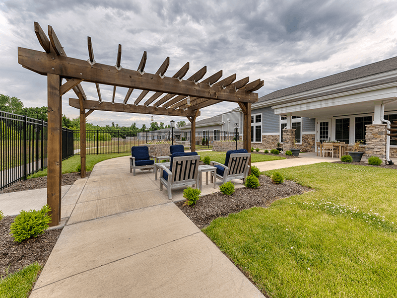 An inviting outdoor patio space with a wooden pergola at Cedarhurst of Blue Springs senior living community.