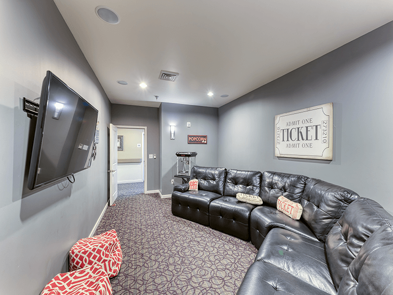 A comfortable and accessible movie theater at Cedarhurst of Breese, featuring a large screen and plush seating for residents' enjoyment.