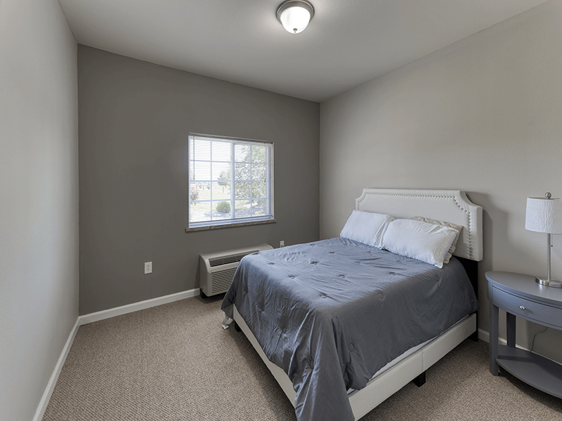 A comfortable and private bedroom within a senior apartment at Cedarhurst of Breese.